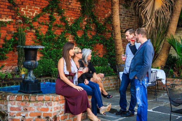 a group of people sitting on a bench talking on a cell phone